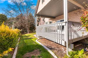 Deck leads to pretty yard with mature trees