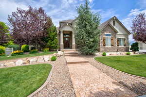 Craftsman house with stone siding, a front lawn, and board and batten siding