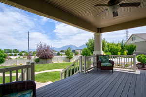 Porch with a fenced backyard, ceiling fan, and a mountain view