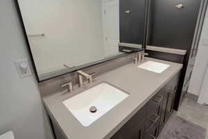 Bathroom featuring double vanity and light tile patterned flooring