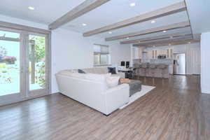 Living area with recessed lighting, beam ceiling, and dark wood-style floors