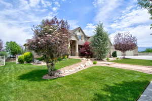 View of front facade featuring covered porch, driveway, and stucco siding