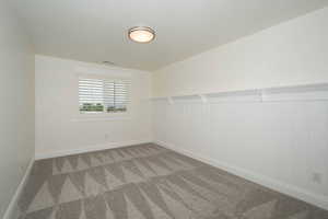 Spare room featuring carpet flooring and baseboards