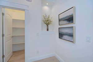 Hall with light wood-style flooring and baseboards
