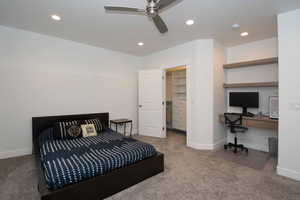 Bedroom featuring light colored carpet, recessed lighting, a spacious closet, a ceiling fan, and an office area