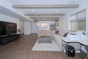 Living area featuring wood finished floors, beamed ceiling, and recessed lighting