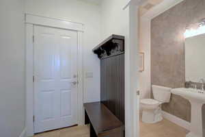 Mudroom featuring light wood-style flooring and tile walls