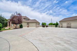 View of home's exterior featuring stone siding, stucco siding, and concrete driveway