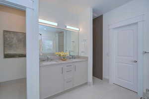 Full bathroom with light tile patterned floors and double vanity