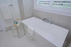Full bathroom with a soaking tub and tile patterned floors