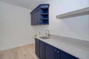 Laundry room with light wood-type flooring, cabinet space, and hookup for a washing machine