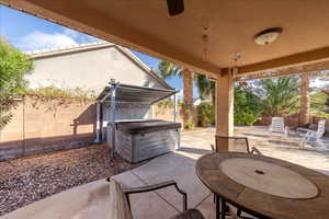Fenced backyard featuring a patio area, a hot tub, and outdoor dining space