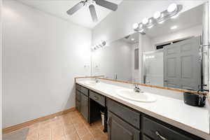 Bathroom with light tile patterned flooring, double vanity, and a stall shower