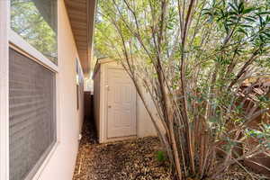 View of side of home with a storage unit