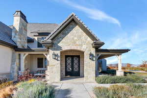 Entrance to property with stone siding and a porch