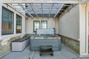 View of patio / terrace featuring a hot tub and a pergola