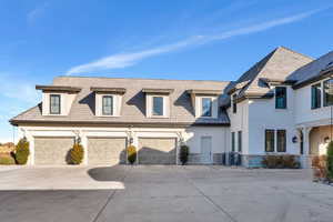 View of front of property with concrete driveway, a garage, and stucco siding