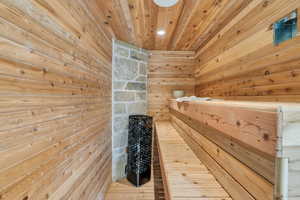 Relaxing sauna with wooden walls, wood ceiling, hardwood / wood-style flooring, and recessed lighting