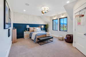 Bedroom featuring light colored carpet, an accent wall, and recessed lighting