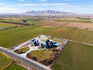 Aerial view of sparsely populated area featuring a mountain backdrop and rows of crops