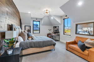 Carpeted bedroom with recessed lighting, wooden walls, and vaulted ceiling