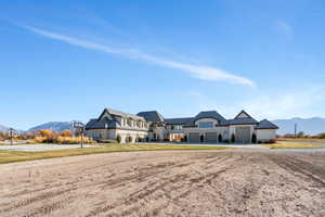 French country style house featuring a mountain view, driveway, and stone siding