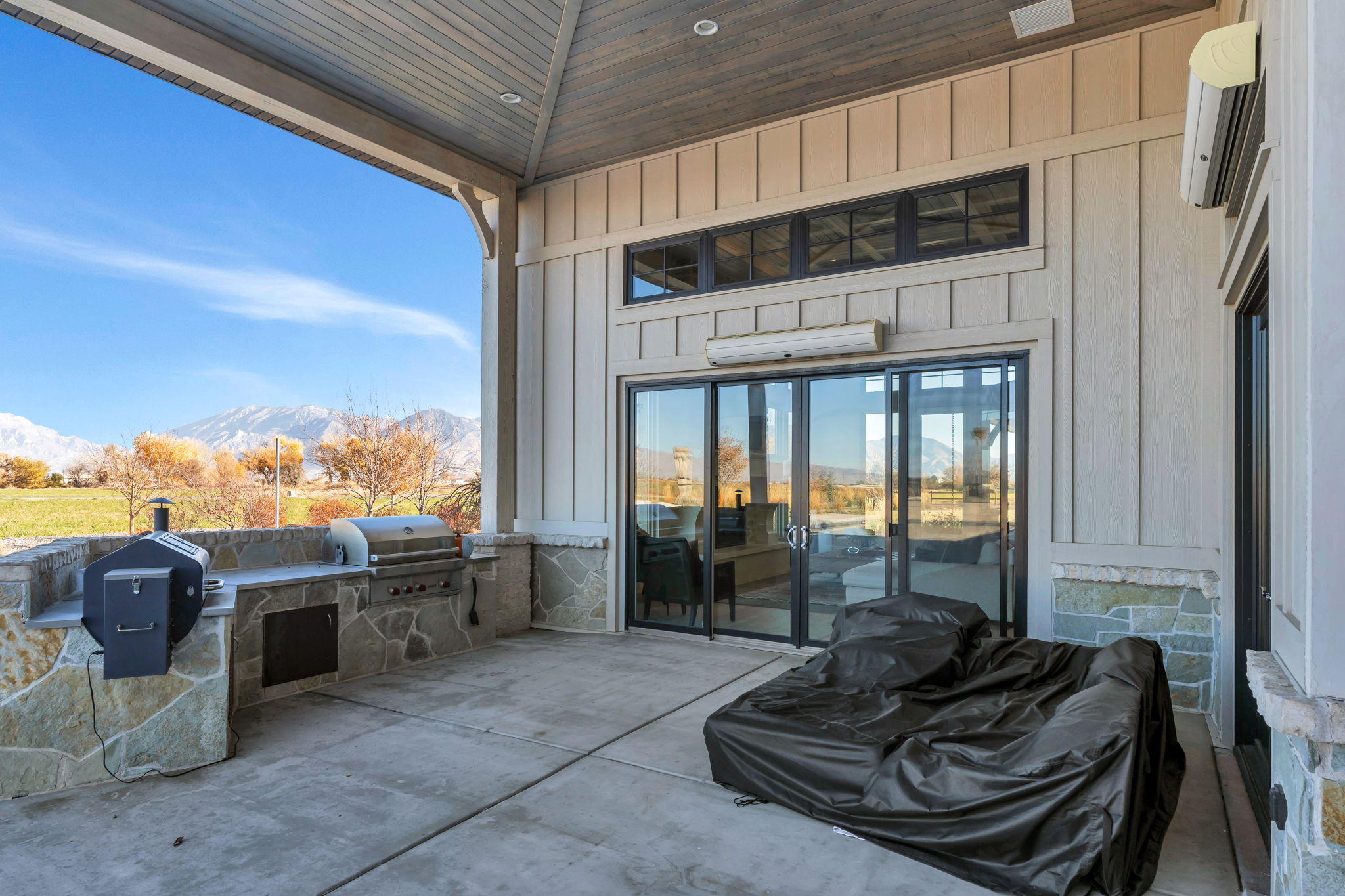 View of patio / terrace featuring a mountain view, exterior kitchen, and a wall mounted air conditioner