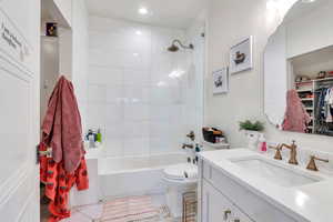 Bathroom featuring vanity, bathing tub / shower combination, light tile patterned floors, and a spacious closet