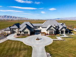 French country inspired facade featuring stone siding, a mountain view, curved driveway, and stucco siding