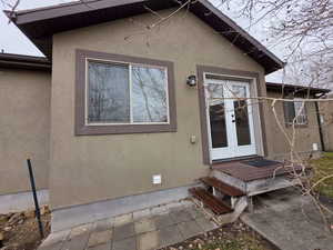Doorway to property featuring french doors and stucco siding