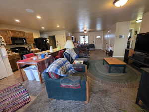 Living room with recessed lighting, light tile patterned floors, and light colored carpet