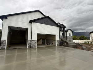 View of side of home featuring stone siding, a mountain view, and board and batten siding
