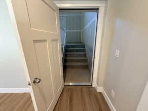 Stairs featuring wood finished floors and baseboards