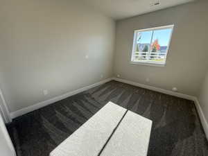 Carpeted spare room with baseboards