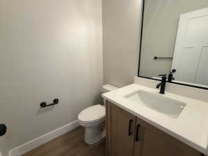 Half bathroom with vanity and dark wood finished floors
