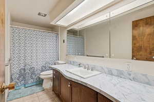 Full bath with a shower with curtain, light tile patterned floors, and vanity