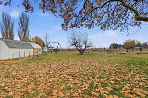 View of yard featuring an outbuilding, a playground, and a view of rural / pastoral area