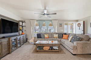 Living room featuring light carpet, a textured ceiling, and ceiling fan