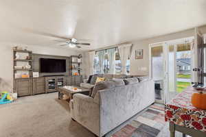 Carpeted living area featuring a textured ceiling and a ceiling fan