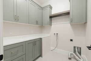 Laundry area with hookup for a washing machine, electric dryer hookup, and cabinet space