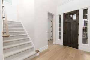 Foyer entrance featuring light wood finished floors and stairway