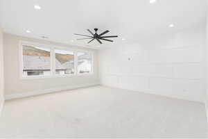 Empty room featuring a decorative wall, light colored carpet, recessed lighting, and ceiling fan