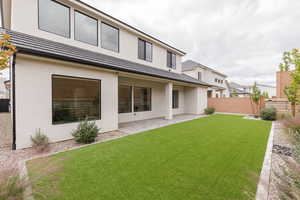 Rear view of property with a patio, stucco siding, and a fenced backyard