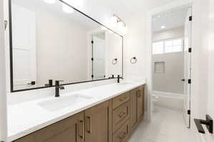 Bathroom featuring double vanity, light tile patterned flooring, and bathtub / shower combination