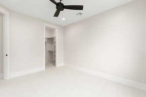 Unfurnished bedroom featuring light carpet, recessed lighting, a spacious closet, and a ceiling fan