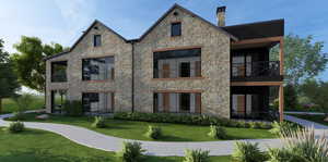 Back of property featuring a balcony, a lawn, stone siding, and a chimney
