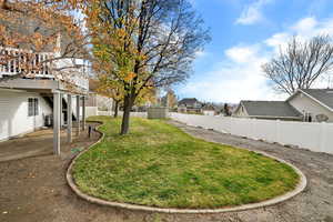 Fenced backyard featuring a residential view, a patio, and a deck