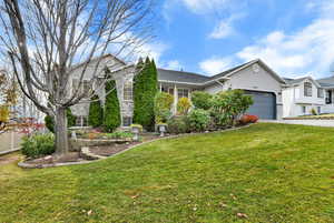 View of front of home with a front lawn, stucco siding, driveway, and a garage