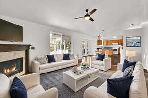 Living area with ceiling fan, vaulted ceiling, a high end fireplace, and french doors
