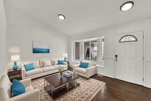 Living area with vaulted ceiling and dark wood-type flooring